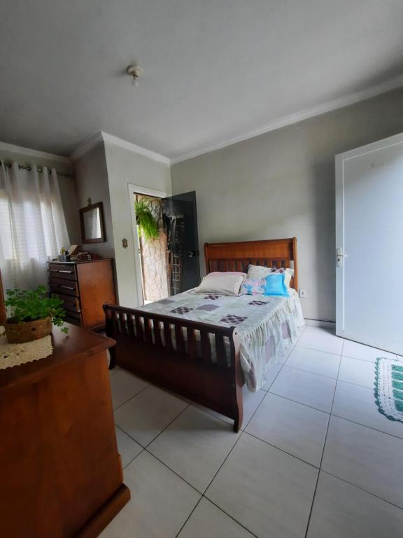 a bedroom with a bed and a dresser in it at CANTINHO VOLTE SEMPRE in Aparecida