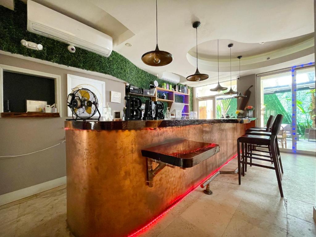 a kitchen with a bar with a wooden counter top at Cento Collins Stays by Mercury South Beach in Miami Beach