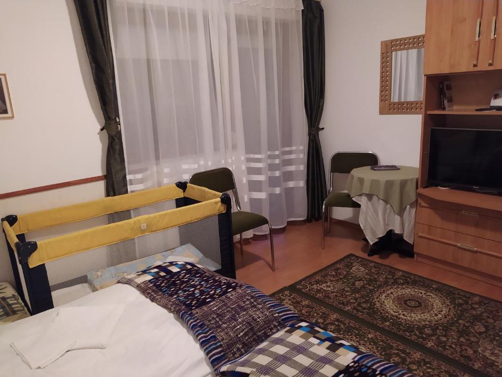 una camera con letto, televisore e tavolo di Nimród Pihenőház a Egerszalók