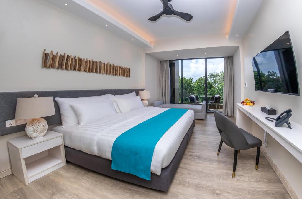 蒂夫斯的住宿－Sky Beach Maldives - Dhiffushi，一间卧室配有一张床和一张桌子及椅子
