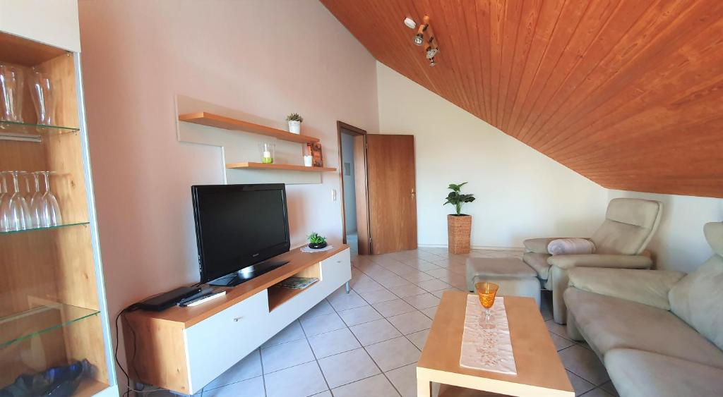 a living room with a couch and a flat screen tv at Gästehaus Reinke - nahe Europa-Park in Ettenheim
