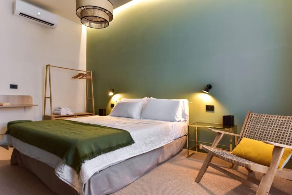 Appartamento Roma San Giovanni في روما: غرفة نوم بسرير كبير وكرسي