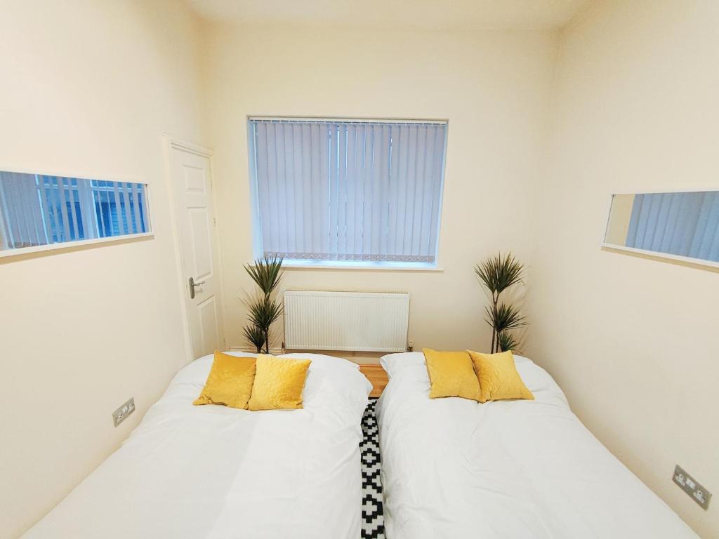 two beds in a room with two windows at Newhall Street Apartment in Birmingham