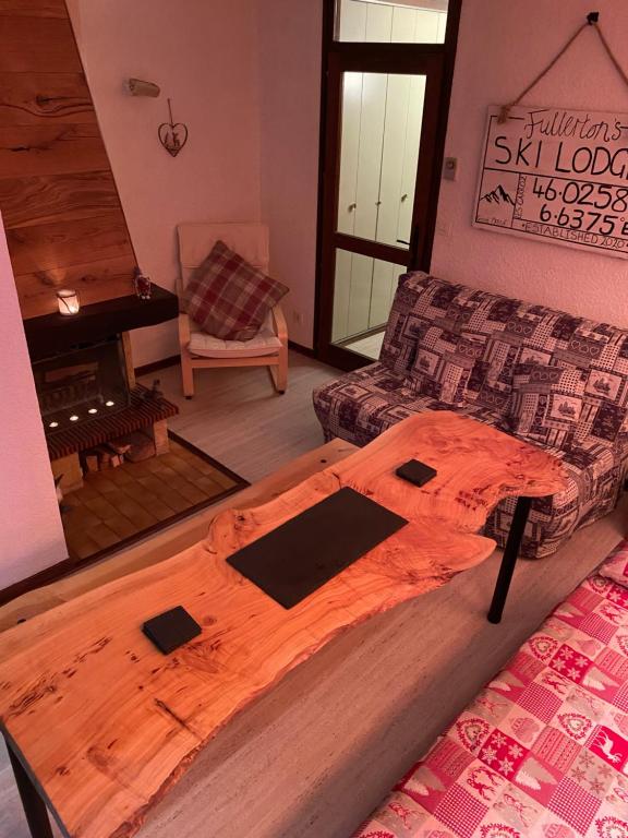 een houten bed in een kamer met een bank bij Loge des rêveurs in Les Carroz d'Araches