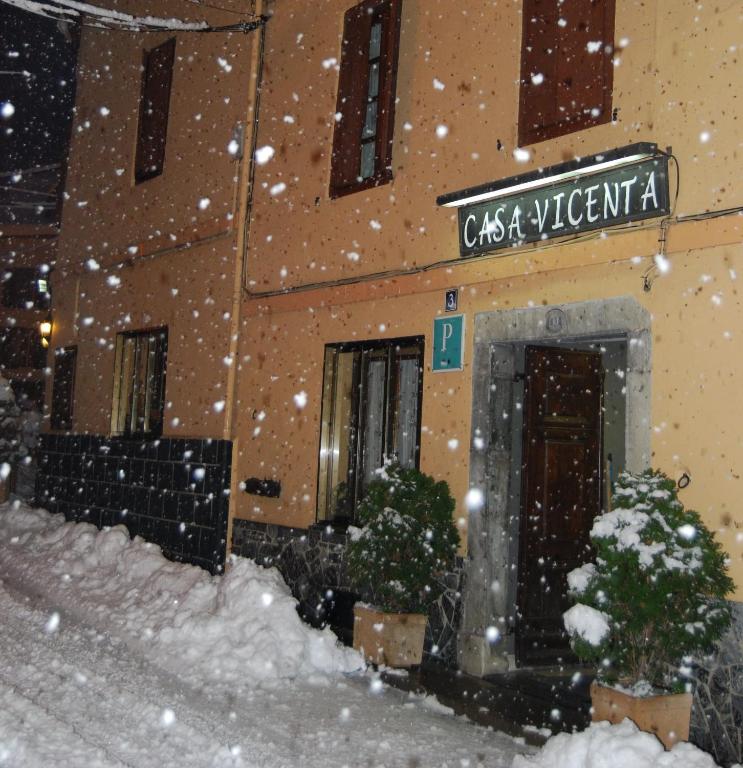 a building with snow falling in front of it at Pension Casa Vicenta in Vielha