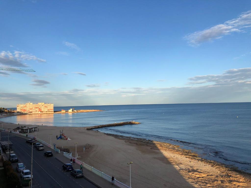 ein Strand mit Autos auf dem Wasser in der Unterkunft Alojamiento Torrevieja playa frente al mar in Torrevieja