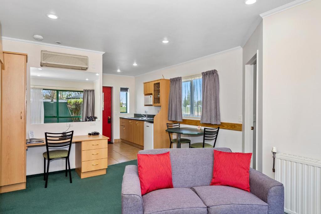 a living room with a couch and a kitchen at The Lakes Motel in Twizel