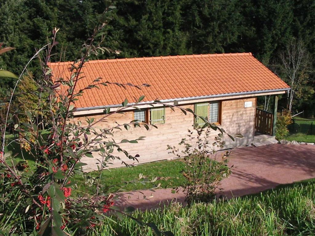 een klein houten huis met een oranje dak bij Gîte Les Noes, 3 pièces, 4 personnes - FR-1-496-239 