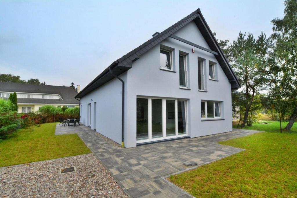 a white house with a courtyard in front of it at holiday home, Mielenko in Mielenko