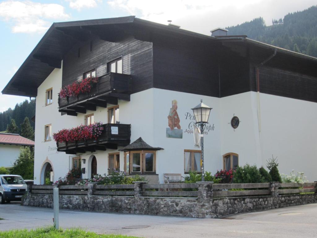 a white building with balconies and flowers on it at Pension Appartments Christoph in Westendorf