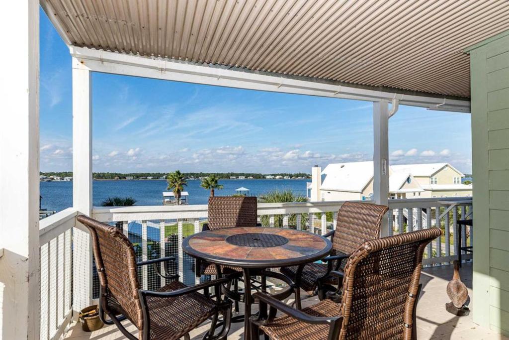 eine Terrasse mit einem Tisch und Stühlen auf dem Balkon in der Unterkunft Lagoon Landing in Gulf Shores