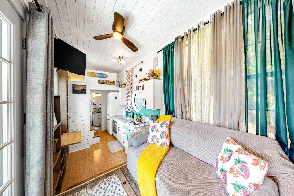 a living room with a couch and a ceiling fan at Chimney Rock Tiny Home in Canyon Lake