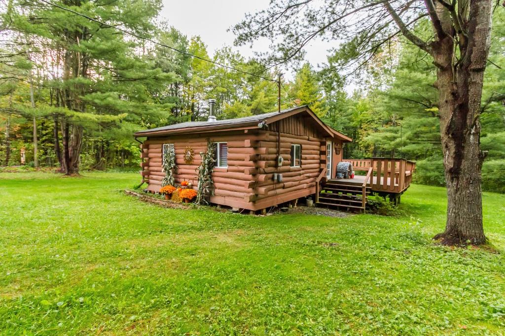 a log cabin with a bench in a yard at Kuebel's Kabin in Prattsburg