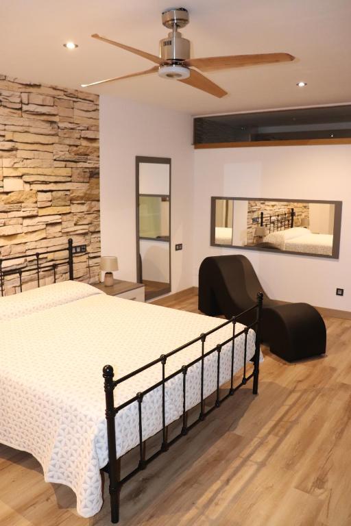 1 dormitorio con 1 cama grande y pared de piedra en Loft romàntic Ca l'Enric Viqué-Baix Empordà, en Regencós