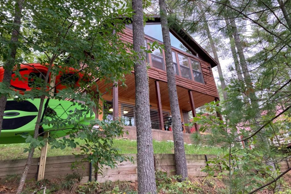 una casa de madera en el bosque con árboles en Camp Two Loons, en Oxford