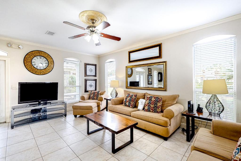 a living room with a couch and a tv at Emerald Shores Cottage in Destin