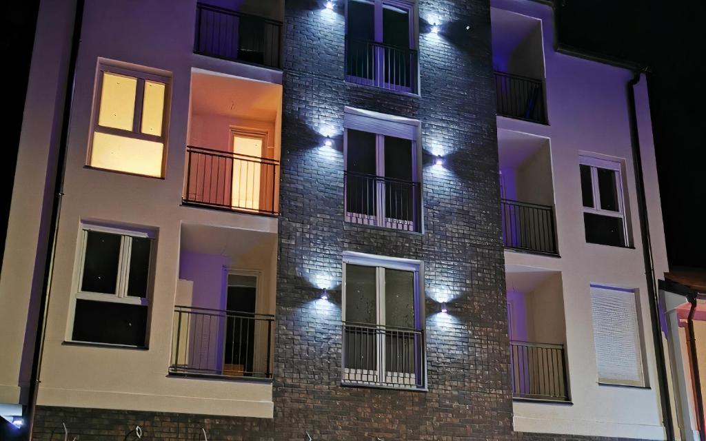 um edifício de apartamentos à noite com luzes acesas em Millenium apartment em Sokobanja