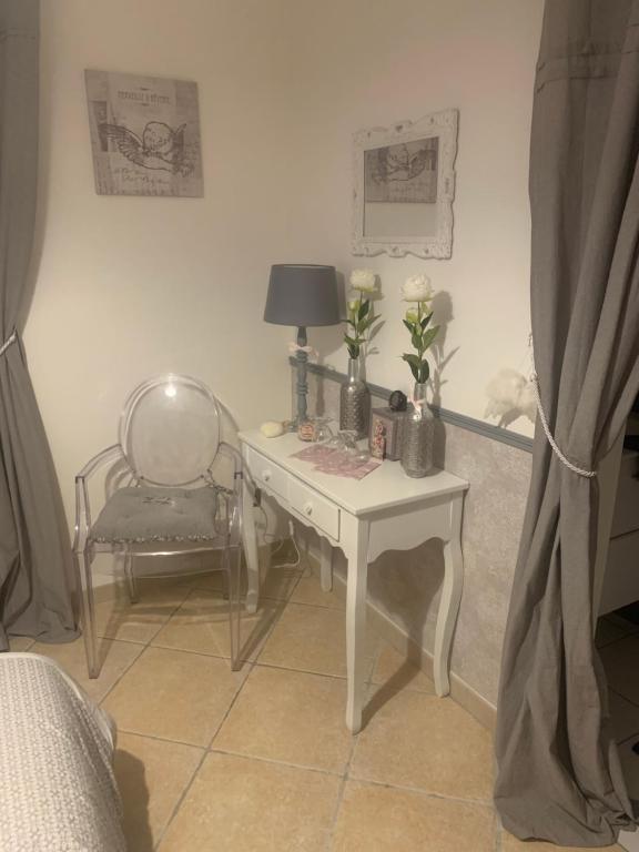 a white desk with flowers and a chair in a room at Mon rêve in Les Martys