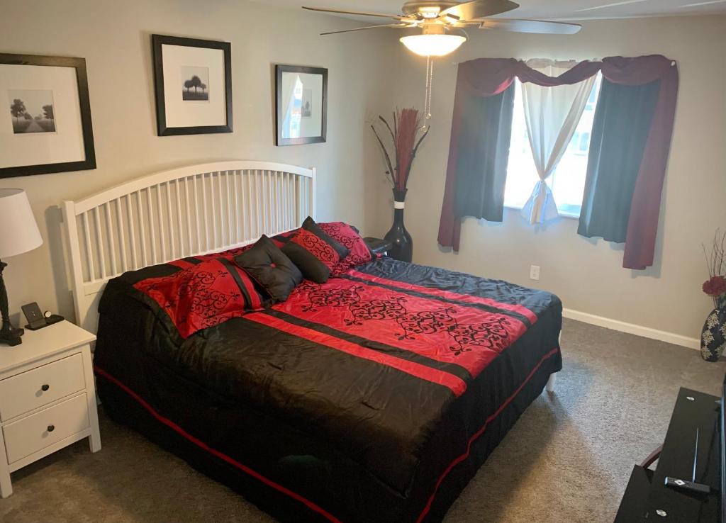 a bedroom with a bed with red pillows and a window at Your home close to Anshutz and DIA in Aurora