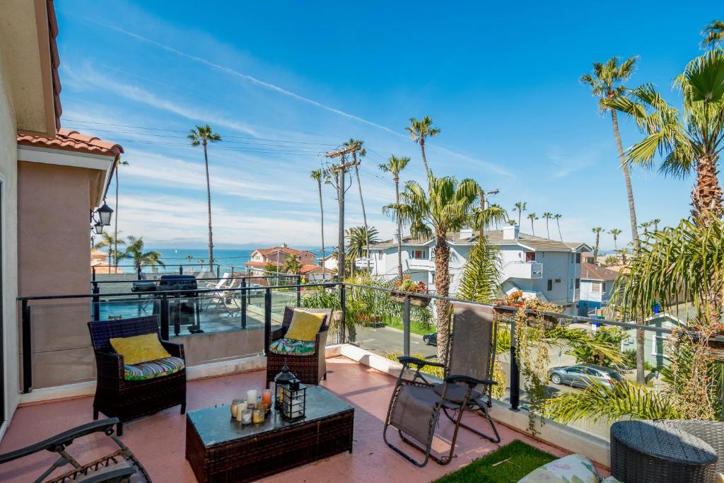 a balcony with a view of the ocean and palm trees at Holiday Home in Oceanside