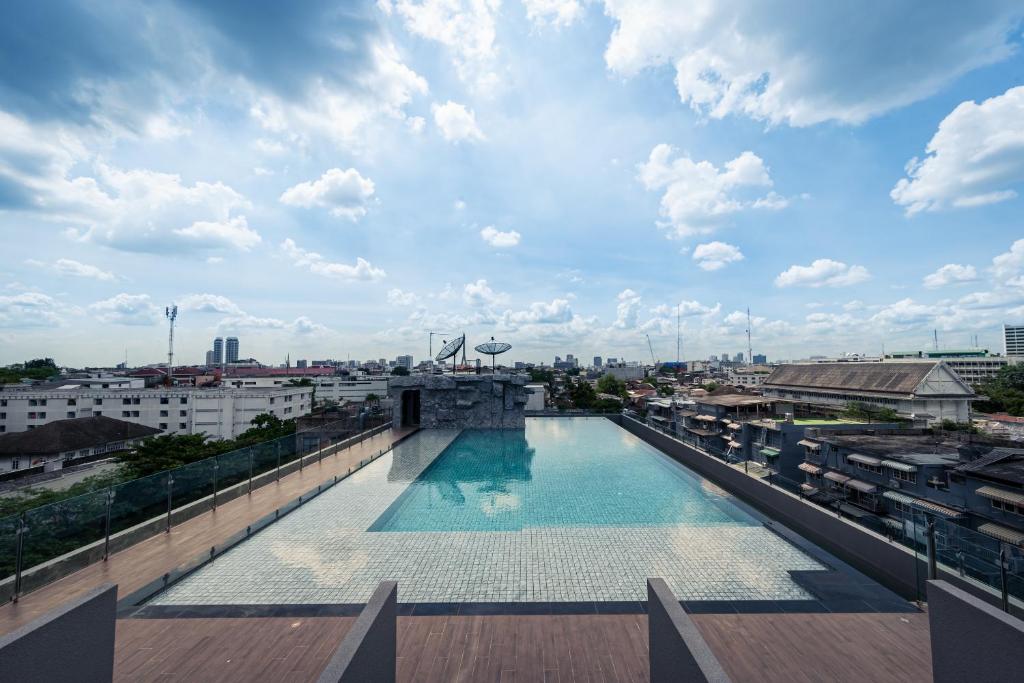 A rooftop infinity-style pool looking across Bangkok’s low-rise cityscape.