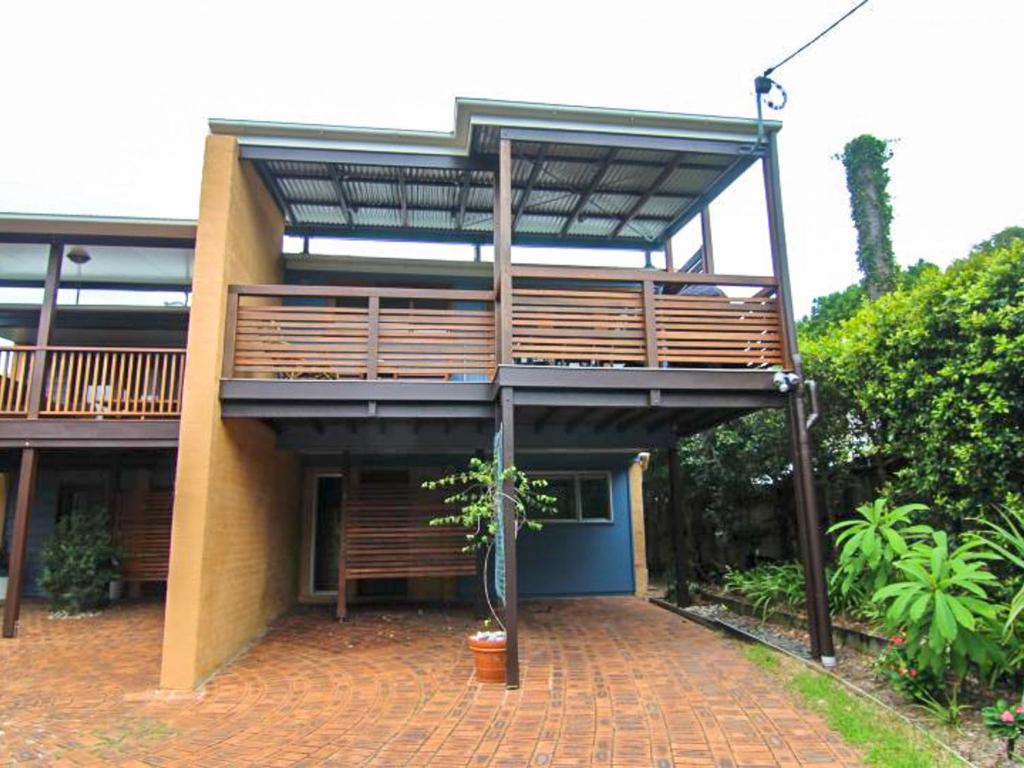 a building with a balcony on a brick patio at Two Sands by Discover Stradbroke in Point Lookout