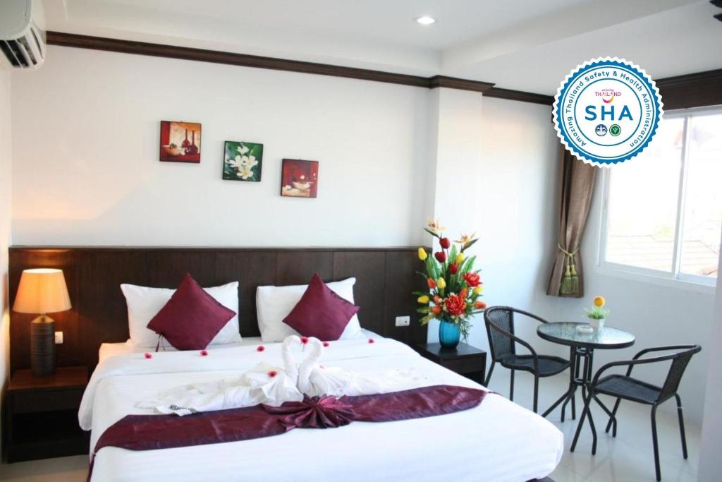 1 dormitorio con 1 cama grande y 1 mesa en Fruit Paradise Hotel, en Patong Beach