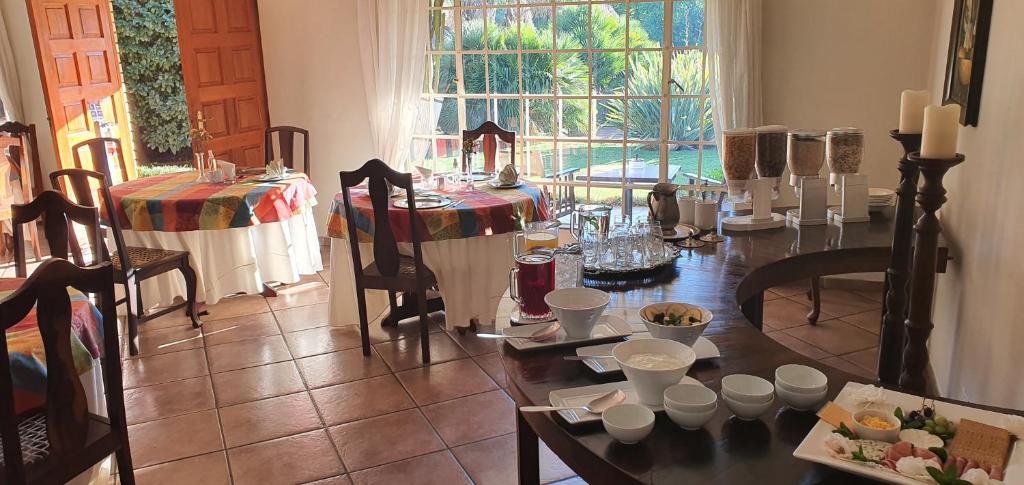 comedor con mesa, sillas y ventana en Avant Garde Lodge, en Kempton Park