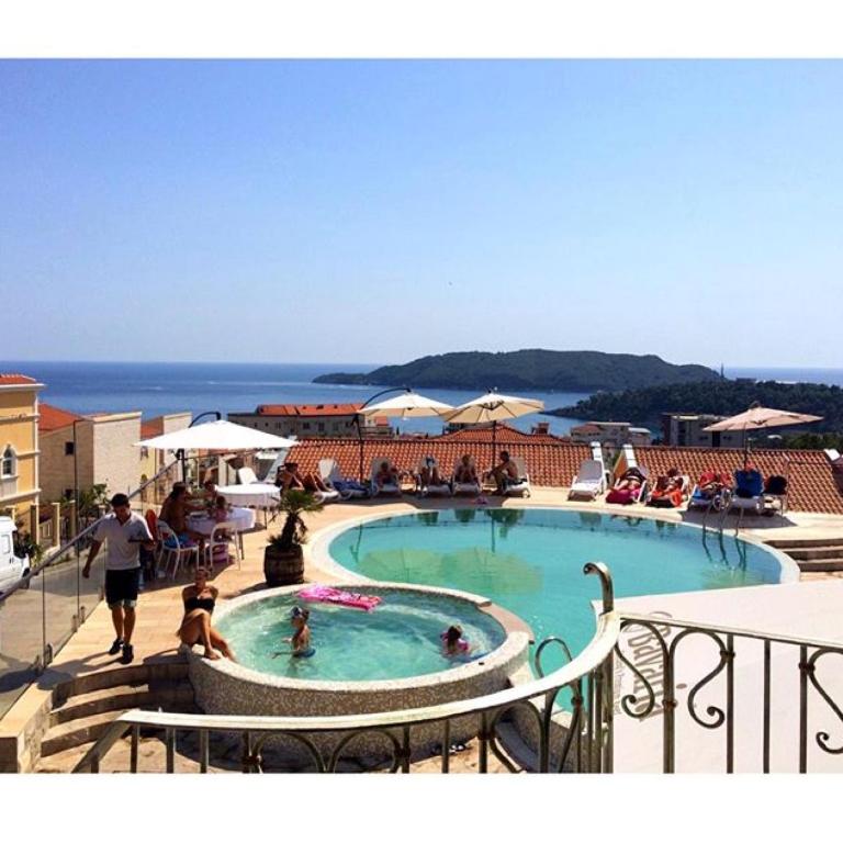 a large swimming pool with people in the water at Spa Resort Luxury Apartments in Budva