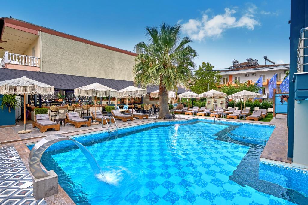 a swimming pool with chairs and umbrellas at a hotel at Principal New Leisure Hotel in Paralia Katerinis