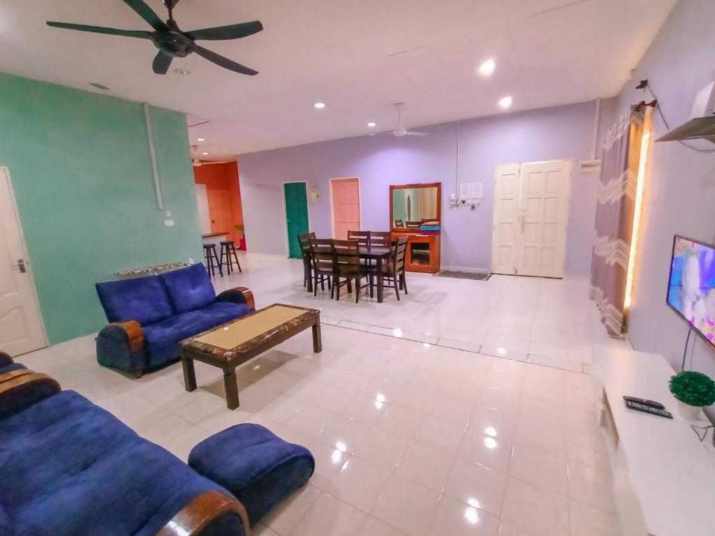 a living room with a blue couch and a table at Villa Bonda Langkawi in Pantai Cenang