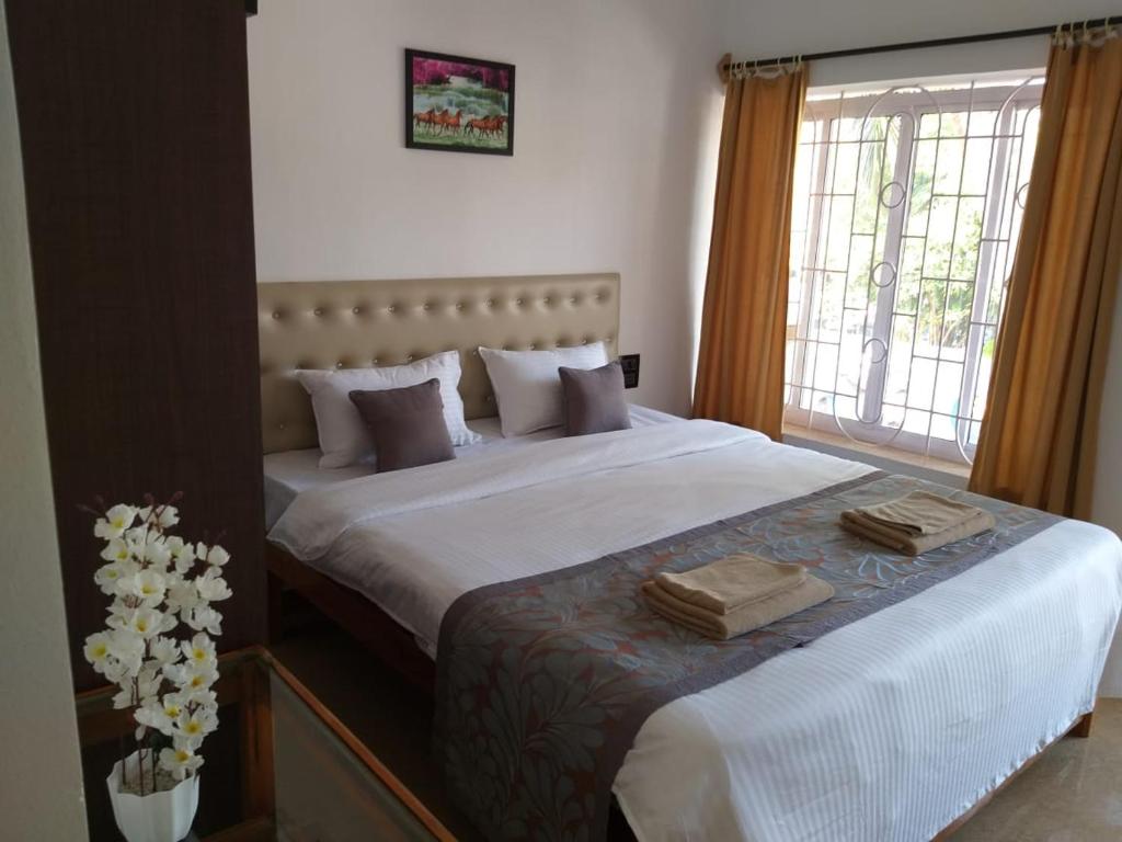 a bedroom with a large bed with two towels on it at Oasis Beach Resort in Agonda