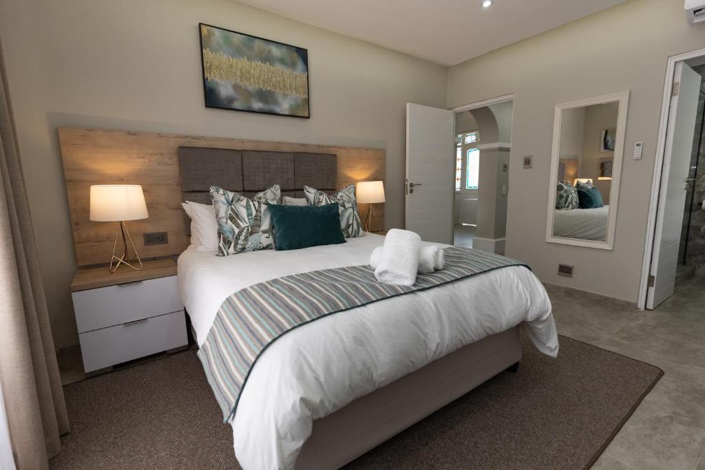 a bedroom with a large bed and a mirror at Caribbean Estates - 35 Montego Bay by Luxe in Port Edward