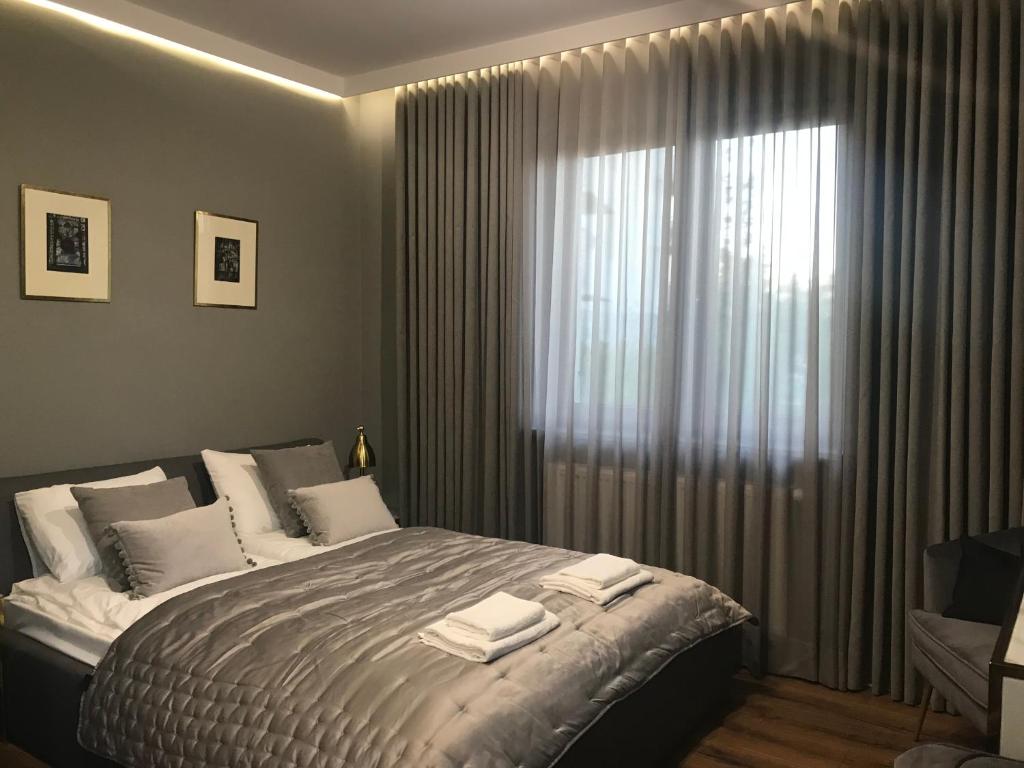 sypialnia z łóżkiem i dużym oknem w obiekcie Apartament SUNTIME w Radomiu