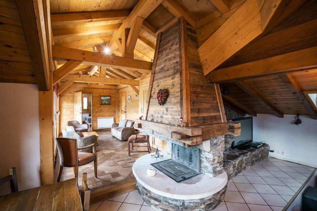 a living room with a stone fireplace in a house at Chalet LouBochu Châtel Réservation in Châtel