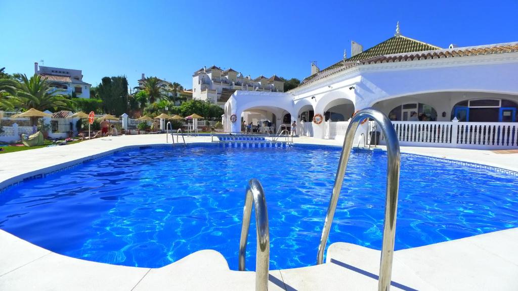 a swimming pool in a villa with blue water at R838 Capistrano Playa 213 in Nerja