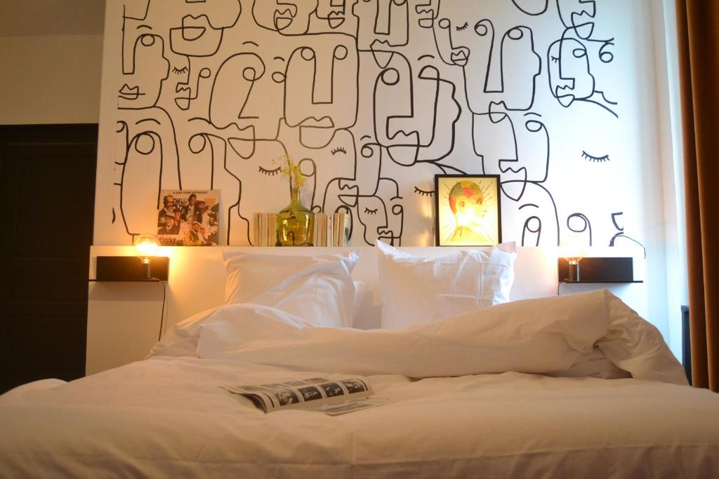 a bedroom with a white bed with a black and white wall at Artefact in Lamballe