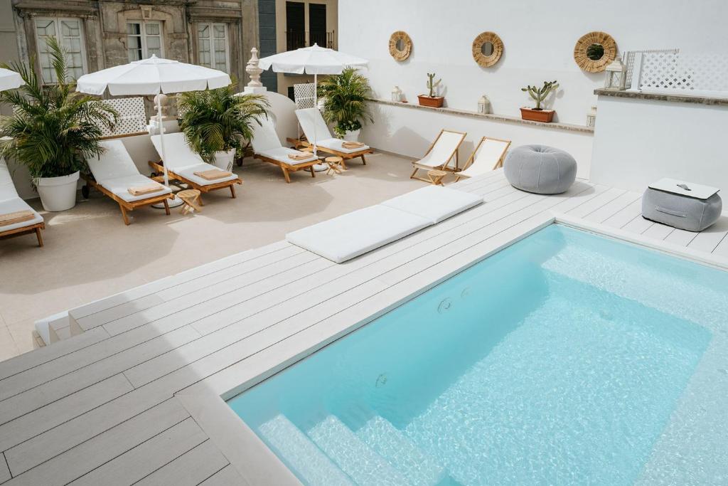 een zwembad op een patio met stoelen en een zwembad bij Emblemático F24-Only Adults B&B in Santa Cruz de Tenerife