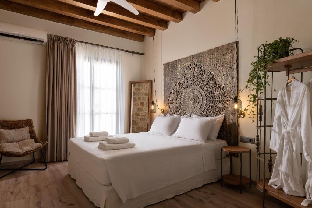 um quarto com uma grande cama branca e uma janela em San Antonio Luxury Apartments, Medieval Town in Ilha de Rhodes