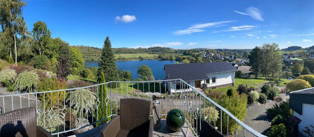 a view from the balcony of a house with a lake at Traumhaus am Maar in Schalkenmehren