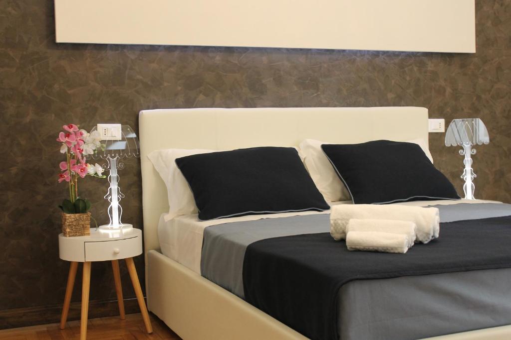sypialnia z łóżkiem z czarno-białymi poduszkami w obiekcie Little Rose Haven w Rzymie