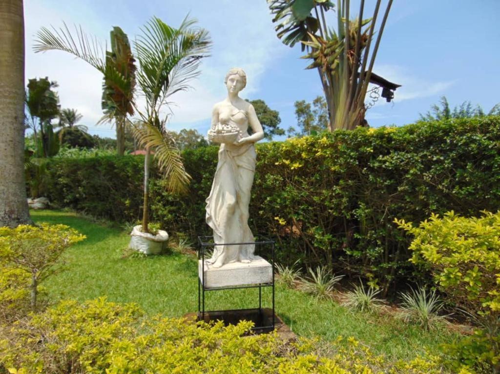 a statue of a woman in a garden at St. Patrick’s Forest House in Entebbe