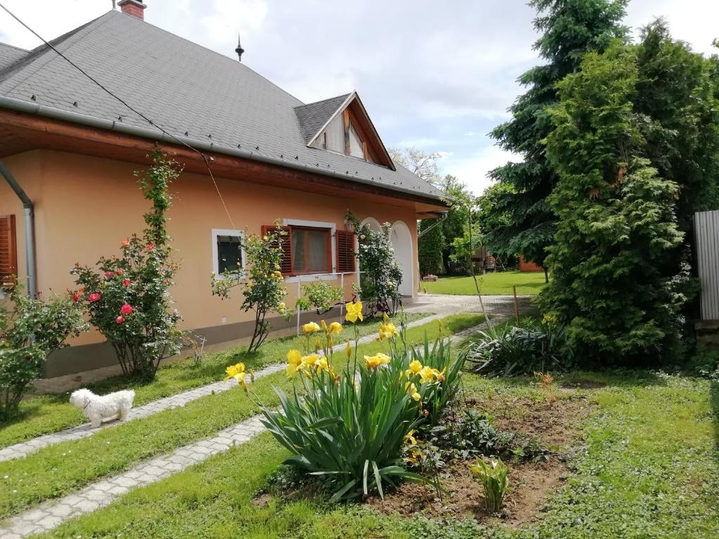 una casa con un perro en el patio en Varga Apartman, en Balatonberény