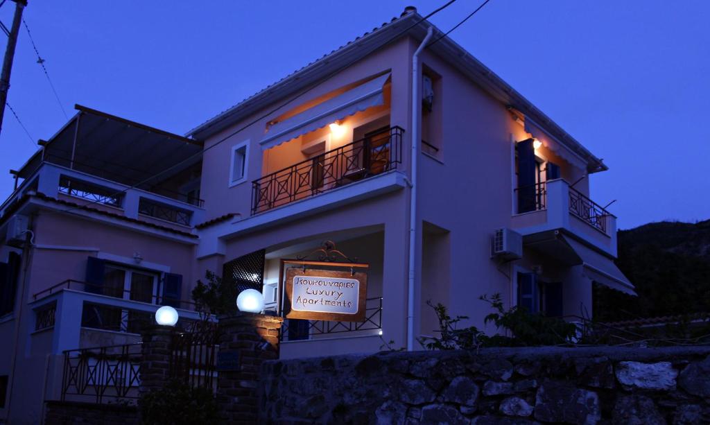 a large white building with a sign in front of it at Koukounaries Apartments Limni in Límni