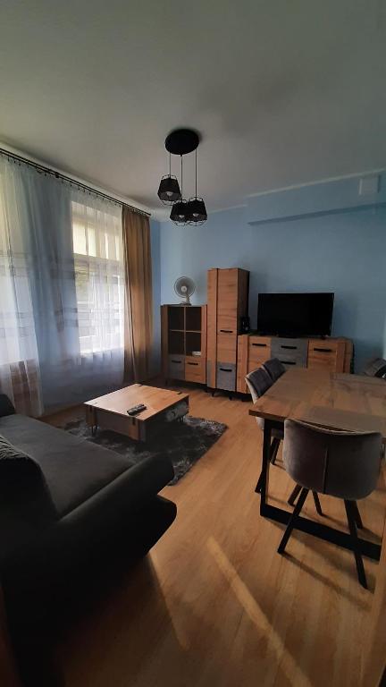a living room with a table and a couch at Apartament w Kudowie-Zdrój in Kudowa-Zdrój