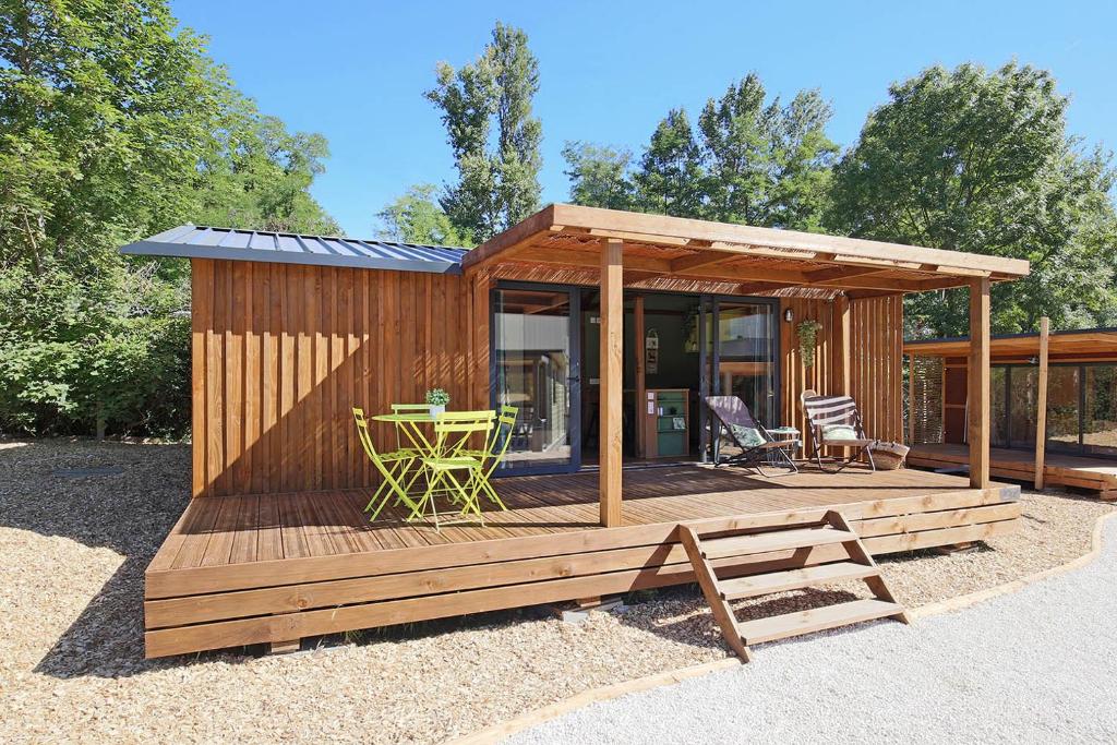 een hut met een terras met een tafel en stoelen bij Les Lodges Chalets by Le Marintan in Saint-Michel-de-Maurienne