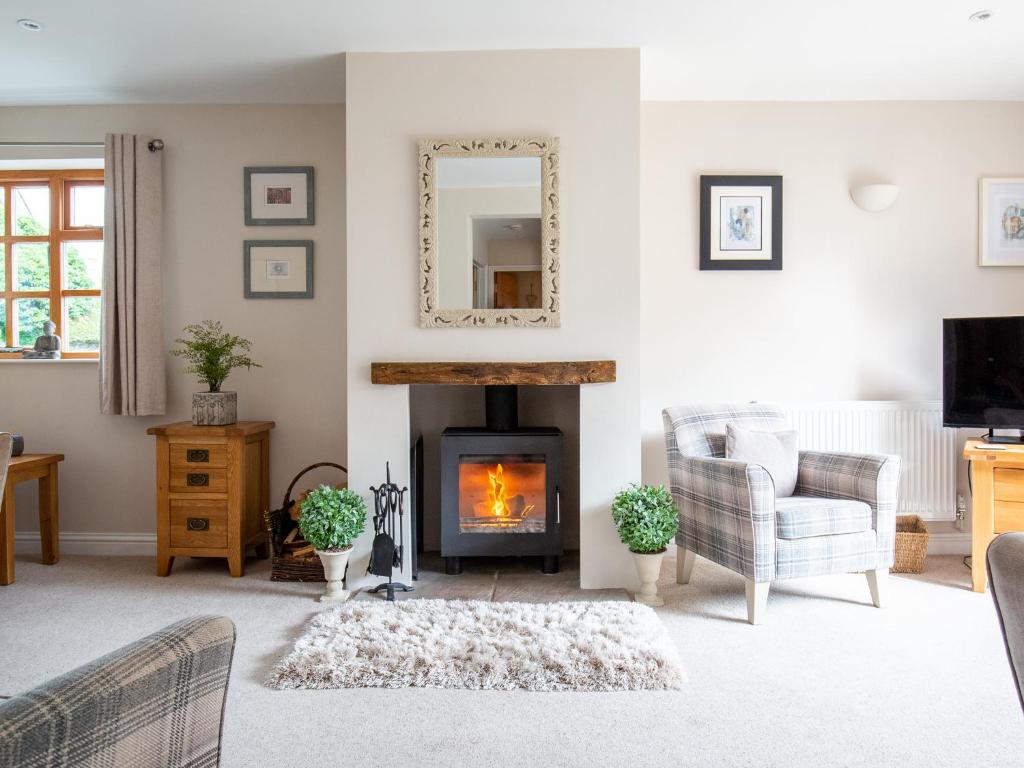 a living room with a fireplace and a mirror at Teagles Cottage in Stow on the Wold