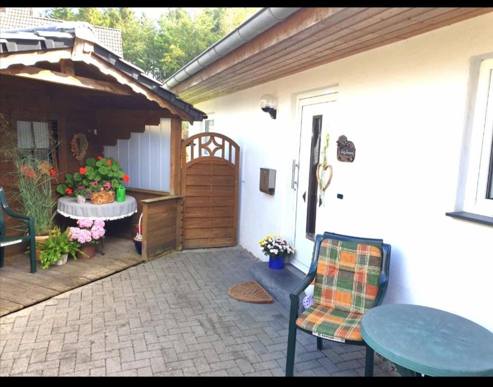 Balve的住宿－Ferienwohnung mit Terrasse für bis zu 4 Personen，一个带桌椅的庭院和一座建筑