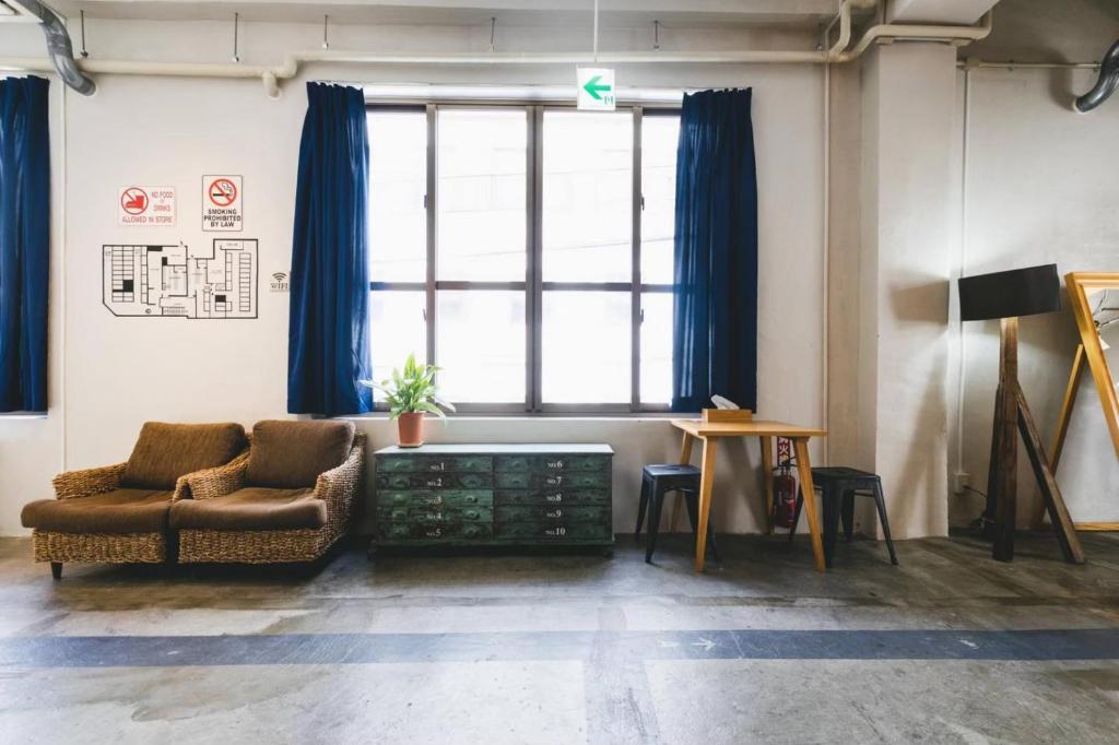 a living room with a couch and a large window at The Kitchen Hostel Ao in Naha