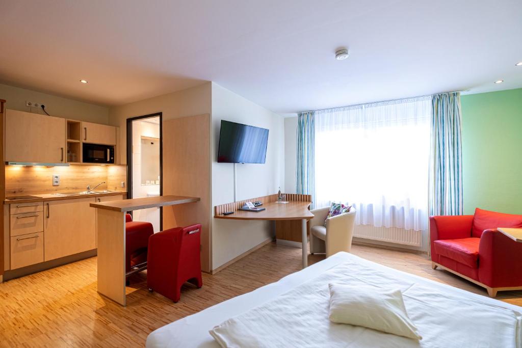 a hotel room with a bed and a kitchen at Hotel Am Froschbächel in Bühl